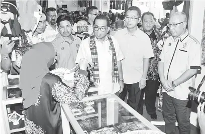  ?? — Gambar Bernama ?? TERTARIK: Mohamed Khaled (dua kiri) melawat gerai Rehamna Enterprise yang menjual produk kraf tangan dari Sabah selepas merasmikan Pasar Muafakat Sabah yang dibuka di Jalan Suria 66, Bandar Seri Alam semalam.