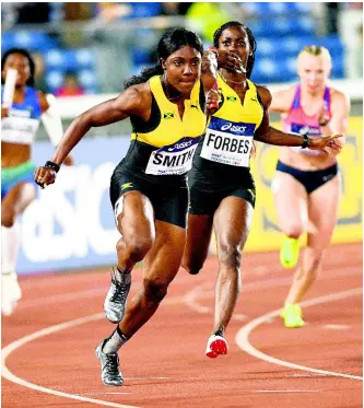  ?? RICARDO MAKYN/CHIEF PHOTO EDITOR ?? Jonielle Smith (left) receives the baton from Shashalee Forbes in the women’s 4x100 metres relay heat at the IAAF World Relays in Yokohama, Japan. The Jamaicans finished second in 43.08 seconds to book a spot in today’s final.