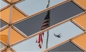  ?? Photograph: Sajjad Hussain/AFP/Getty Images ?? The Stars and Stripes is reflected on the windows of the US embassy building in Kabul.