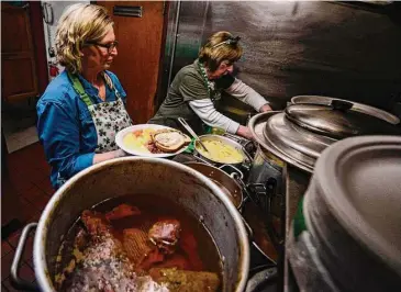  ?? Kristopher Radder/Associated Press ?? Jane Ryan, co-owner of Donovan's in Bellows Falls, Vermont, and Ellen Podgurski, a helper, get plates of corned beef ready for customers on St. Patrick's Day on Friday.