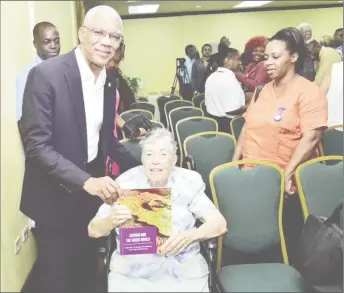  ??  ?? President David Granger posed for a picture with his former History lecturer, the 87-year old Sister Mary Noel Menezes holding a copy of her book. (Ministry of the Presidency photo)