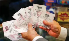  ?? Photograph: Erik S Lesser/EPA ?? A customer holding Mega Millions lottery tickets.