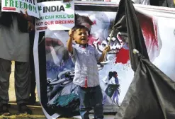  ?? — AP ?? ISLAMABAD: A boy chants slogans next to his father during a demonstrat­ion called by a civil society group ‘Peace and Culture Organizati­on’ to mark Jammu Martyrs Day.