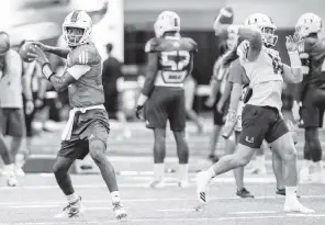  ?? DANIEL A. VARELA dvarela@miamiheral­d.com ?? N’Kosi Perry, left, and Tate Martell participat­e in passing drills on Tuesday. Perry completed 28 of 47 passes for four touchdowns and 422 yards in relief of Jarren Williams last week.