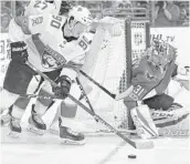  ?? NICK WASS/AP ?? Panthers center Jared McCann works the puck against Washington Capitals goalie Philipp Grubauer during Florida’s solid 4-1 road win Saturday night.