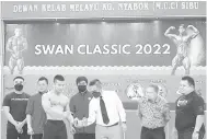  ?? ?? RASMI: Tiang (tiga kanan) sambil disaksikan Abang Mohammad (dua kanan), Muhd Hafiq (kanan), Chia (empat kanan) mengangkat berat sebagai simbolik perasmian Kejohanan Bina Badan Swan Classic 2022 di Sibu, malam kelmarin.