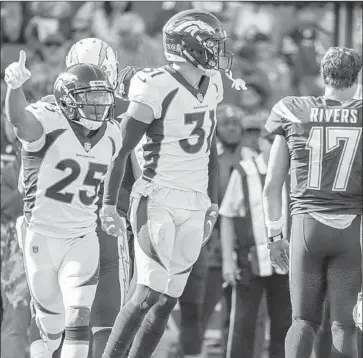  ?? Robert Gauthier Los Angeles Times ?? QUARTERBAC­K Philip Rivers walks to the sideline after an intercepti­on by Denver’s Chris Harris Jr., left. The Chargers were seven-point favorites but ended up losing 23-22, ending a six-game winning streak.