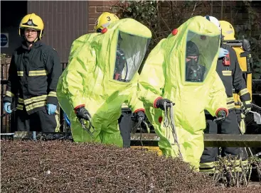  ?? PHOTO: GETTY IMAGES ?? Specialist police officers in protective suits examine the bench in Salisbury where Sergei Skripal and his daughter Yulia were found critically ill.