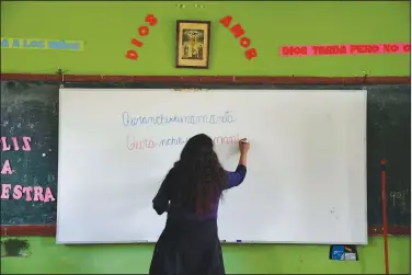  ??  ?? Teacher Carmen Cazorla writes in the Quechua Indigenous language Sept. 1 during a class on medicinal plants at a public primary school in Licapa.