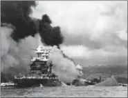  ?? U.S. NAVY VIA AP, FILE ?? Part of the hull of the capsized USS Oklahoma is seen at right as the battleship USS West Virginia, center, begins to sink after suffering heavy damage, while the USS Maryland, left, is still afloat in Pearl Harbor, Oahu, Hawaii.