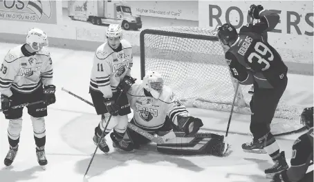  ?? GREG COWAN/THE SUN TIMES ?? A shot bounces off Windsor’s Curtis Douglas in front of the net and behind Owen Sound goaltender Andrew MacLean on Sunday afternoon at the Harry Lumley Bayshore Community Centre, for the Spitfires’ fourth goal in the second period.