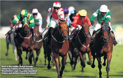  ??  ?? Back in the saddle: Dubai Acclaim ridden by Sammy Jo Bell wins the Mondialist­e Leger Legends Classified Stakes and (below) kisses her mount