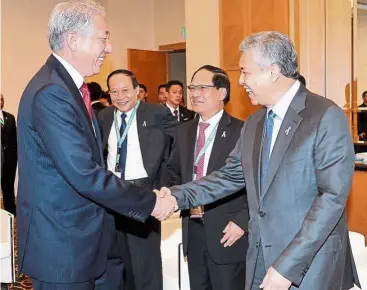  ?? — Bernama ?? Tough action: Dr Ahmad Zahid exchanging plesantrie­s with Teo (left) at the 5th Asean Ministeria­l meeting on drugs.