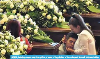  ??  ?? GENOA: Relatives mourn near the coffins of some of the victims of the collapsed Morandi highway bridge, laid in front of the altar, during the funeral service. — AFP