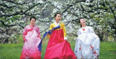  ?? PROVIDED TO CHINA DAILY ?? Ladies enjoy the view of pear blossoms in the Yanbian Korean autonomous prefecture.