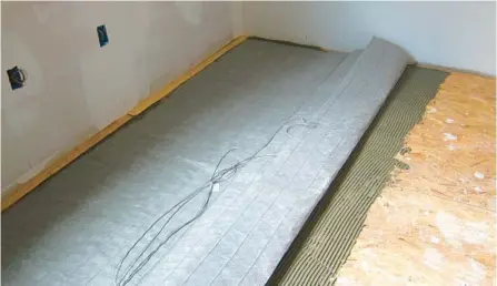  ?? TIM CARTER ?? This fabric mat contains electric heating cables. Finished flooring is installed on top of the mat after it’s covered with a thin coat of sand and cement.