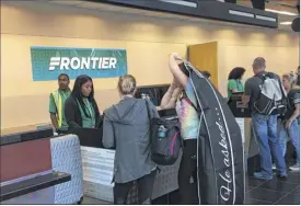  ??  ?? Passengers check in Monday morning for Frontier Airlines’ first flight from Albany to Denver. The ultra-low fare carrier will offer flights to Denver on Mondays and Fridays.