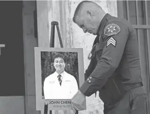  ?? JAE C. HONG/AP ?? Orange County Sheriff’s Sgt. Scott Steinle displays a photo of Dr. John Cheng, who was killed in Sunday’s shooting at Geneva Presbyteri­an Church in Laguna Woods, Calif., after rushing the gunman.