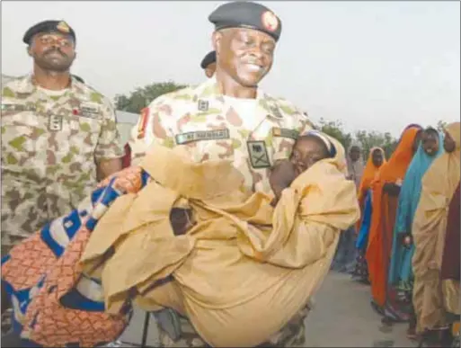  ??  ?? An officer helps a weak Dapchi girl