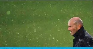  ?? — AFP ?? MADRID: Real Madrid’s French coach Zinedine Zidane stands in the rain during the Spanish League football match between Real Madrid CF and SD Eibar at the Alfredo di Stefano stadium in Valdebebas on the outskirts of Madrid on April 3, 2021.