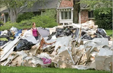  ?? JAY JANNER/AMERICAN-STATESMAN ?? Paige Maupin walks on Contour Place after helping her brother at his flood-damaged home in the Meyerland neighborho­od in Houston after Hurricane Harvey on Sept. 1.