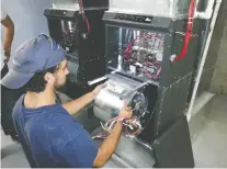  ??  ?? A Duct Masters technician removes the blower and motor from a furnace since, to maximize the air quality in a home, the company offers the cleaning of this equipment in addition to cleaning the ducts.