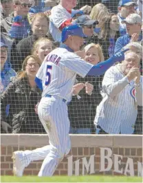  ?? AP ?? The Cubs’ Albert Almora Jr. ( above) reacts after scoring on a sun- aided double by Javy Baez ( right) in the third inning Saturday against the Brewers. Both have 11- game hitting streaks.