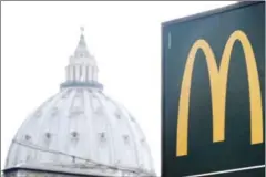  ?? TIZIANA FABI/AFP ?? A McDonald’s restaurant sign is seen with St Peter’s Basilica in the background on January 3 in Rome.