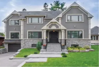  ?? FORESTWOOD REAL ESTATE INC. PHOTOS ?? The stone-and-stucco exterior of the home features a varied roofline and a built-in double-car garage.