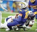  ?? MARCIO JOSE SANCHEZ / AP ?? Denver Broncos defensive end Zach Allen sacks Los Angeles Chargers quarterbac­k Justin Herbert during the first half of Sunday’s game in Inglewood.