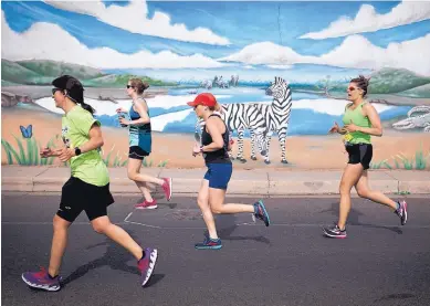  ?? PHOTOS BY MARLA BROSE/JOURNAL ?? Runners make their way to the finish line near a mural at the ABQ BioPark Zoo during the 33rd annual Run for the Zoo on Sunday. The event featured competitor­s and others who were there to have a good time and raise money for the zoo.