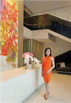  ??  ?? Dr Vicki Belo next to a vibrant isabel Diaz painting ; The Belo Medical Group Greenhills clinic