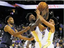  ?? Santiago Mejia / The Chronicle ?? Warriors center-forward Jordan Bell (center) grabs the rebound from teammate Quinn Cook in front of Minnesota rookie Keita Bates-Diop in the second half of the teams’ preseason opener.