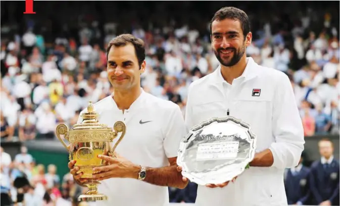  ??  ?? LONDON: Switzerlan­d’s Roger Federer (L) and Croatia’s Marin Cilic pose with their trophies after Federer won their men’s singles final match, during the presentati­on on the last day of the 2017 Wimbledon Championsh­ips at The All England Lawn Tennis...