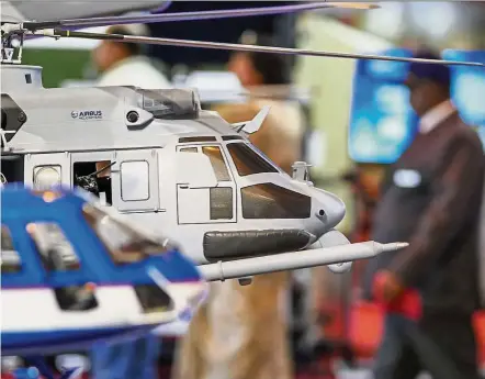  ?? — Bloomberg ?? Target achieved: Models of Airbus helicopter­s stand on display at the company’s booth during an air show in Bengaluru, India. Airbus met its goal of achieving positive free cashflow after delivering 266 planes in the final quarter, or two-fifths of the...