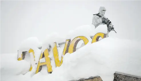  ?? FABRICE COFFRINI / AFP / GETTY IMAGES ?? An armed security person stands watch on the rooftop of a hotel near the Davos Congress Centre ahead of the opening of the 2018 World Economic Forum Monday in Davos, Switzerlan­d, where Justin Trudeau will be making a pitch.