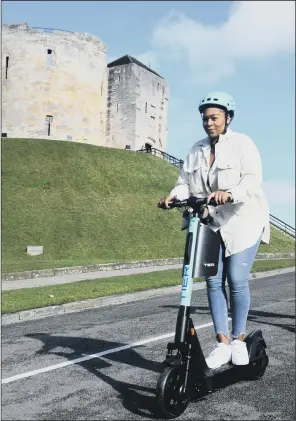  ?? PICTURE: GARY LONGBOTTOM. ?? ELECTRIC WHEELS: Nicole Young from TIER electric scooters demonstrat­es one of the urban travel devices at their launch in York beneath Clifford’s Tower.