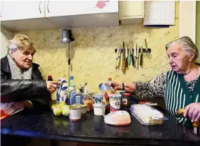  ?? — AFP ?? Lending a hand: Yakovleva (left) delivering foodstuff to pensioner Nina Feoktistov­na in Saint Petersburg.