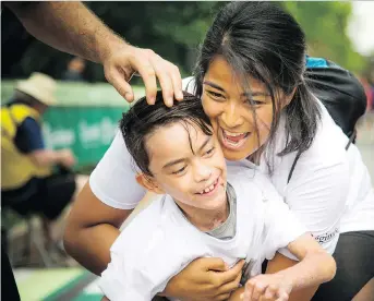  ?? ASHLEY FRASER ?? Yandy Macabuag and her son Evan Prescott finish the 5K race Saturday at Ottawa Race Weekend. Even, who, like Jonathan Pitre, lives with the painful disease EB, used a wheelchair to complete the course.