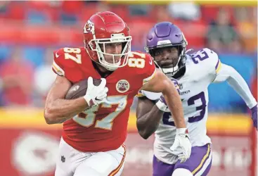  ?? CHARLIE RIEDEL/AP ?? Chiefs tight end Travis Kelce runs after a catch past Vikings safety Xavier Woods in a preseason game Aug. 27 in Kansas City, Mo. Kansas City has been experiment­ing with four-tight end sets.