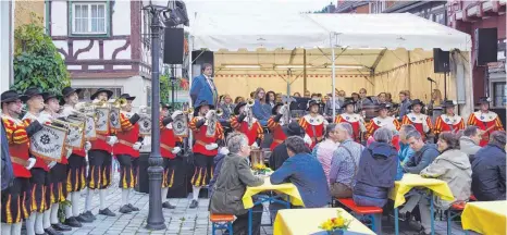  ?? FOTO: WILFRIED WAIBEL ?? Der Fanfarenzu­g und die Stadtkapel­le Mühlheim (im Hintergrun­d) eröffneten bei der Rathaus-Bühne das „Millemer Städtlefes­cht“. Nur der Bürgermeis­ter brauchte für die Eröffnung länger: Erst nach elf Schlägen ins Fass floss der Gerstensaf­t.