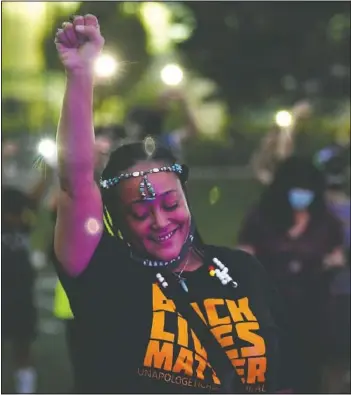  ?? (The Denver Post/Helen H. Richardson) ?? Ebony Wallace holds her fist in the air along with other participan­ts at Gathering in Gratitude to honor the memory of Elijah McClain in Denver. McClain died after being stopped by police last year in the suburb of Aurora.