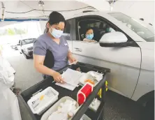  ?? ARLEN REDEKOP ?? A nurse at a drive-thru clinic in Coquitlam prepares to deliver one of a record 52,266 shots administer­ed on Wednesday in B.C.