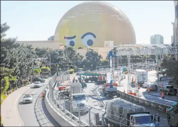  ?? K.M. Cannon Las Vegas Review-journal @Kmcannonph­oto ?? A Sphere emoji looks on as crews remove fencing from the Las Vegas Grand Prix course on Sands Avenue on Nov. 20. At Tuesday’s scheduled meeting, the Clark County Commission will receive a presentati­on on a report about the Formula One race.