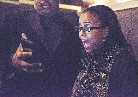  ?? Haley Nelson/Post-Gazette ?? Fay Williams, of Homestead, reacts as her cousin, Todd Glover, of Sheraden, shows her polling results Tuesday at the electionni­ght party for the Judge Dwayne Woodruff.