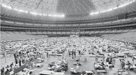  ?? Menahem Kahana / AFP / Getty Images ?? Thousands of New Orleanians fled their city after Hurricane Katrina’s storm surge overtook the levees. For many, the Astrodome was their first respite.