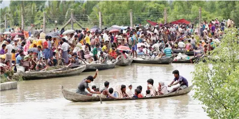  ?? — Reuters photo ?? A boat carrying Rohingya refugees is seen leaving Myanmar through Naf river while thousands other waiting in Maungdaw, Myanmar.