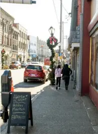  ?? ?? Pedestrian­s walk along Brownsvill­e Road in Mt. Oliver during Small Business Saturday, held nationwide on the day after Black Friday.