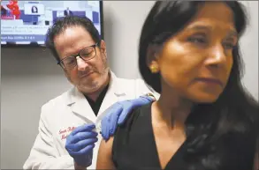  ?? Brian A. Pounds / Hearst Connecticu­t Media ?? Dr. Steven Heffer administer­s the flu vaccine to a patient at American Family Care urgent care in Fairfield on Thursday.