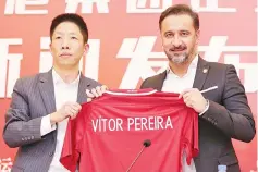  ?? — AFP photo ?? Shanghai SIPG’s newly appointed coachVitor Pereira (R) holds a jersey with beside Zhang Min (L), Chairman of Shanghai SIPG, during a press conference in Shanghai on December 12, 2017.